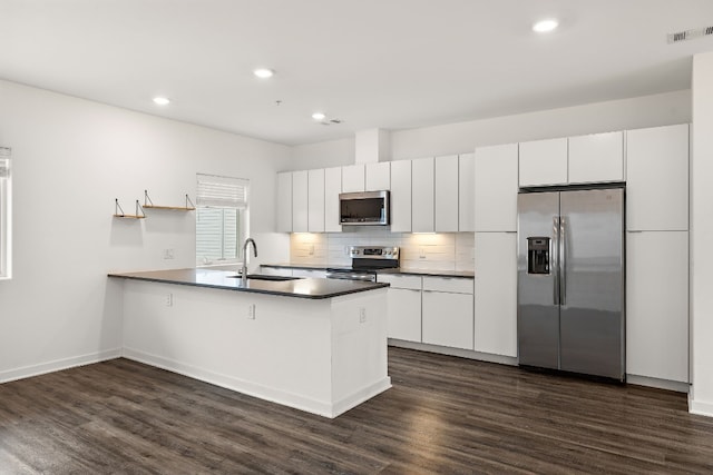 kitchen featuring sink, white cabinetry, tasteful backsplash, dark hardwood / wood-style floors, and stainless steel appliances