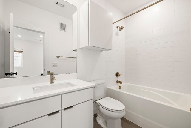 full bathroom with tiled shower / bath combo, vanity, and toilet