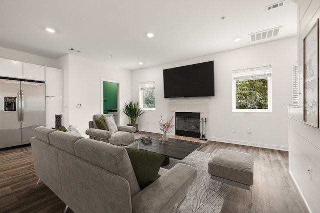 living room featuring a tile fireplace and hardwood / wood-style floors