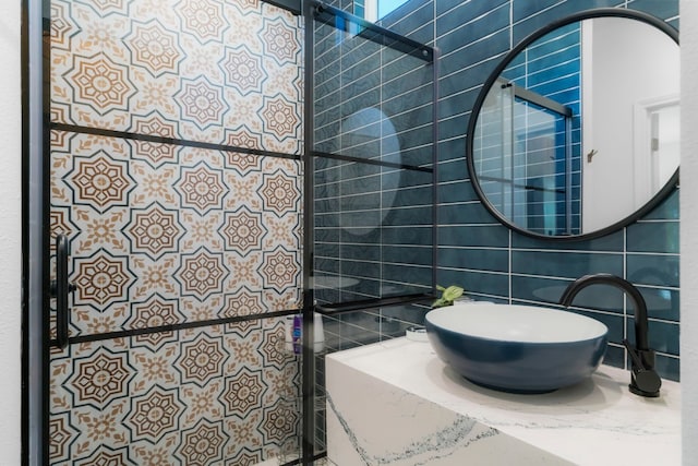 bathroom featuring tile walls, decorative backsplash, and sink