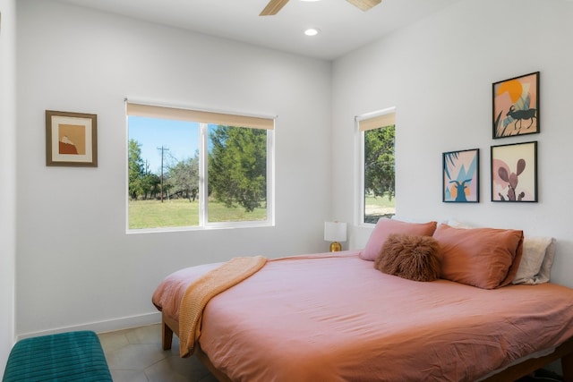 tiled bedroom featuring multiple windows and ceiling fan