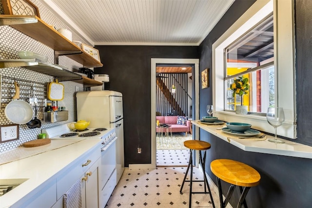 kitchen with white cabinets, white electric stove, ornamental molding, and backsplash