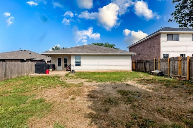 rear view of house featuring a patio area and a yard