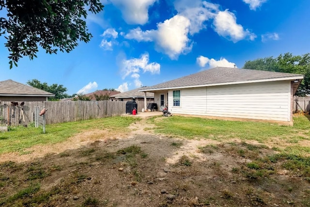 rear view of house with a yard and a patio area