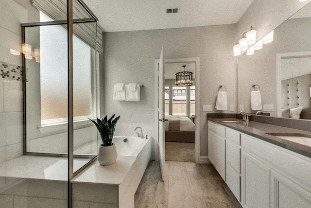 bathroom with separate shower and tub, vanity, and a notable chandelier