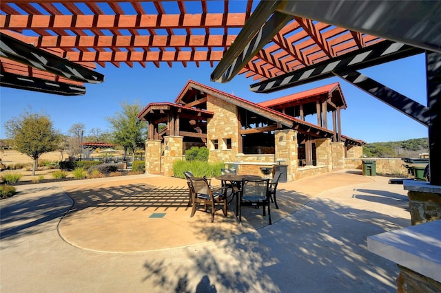 view of patio featuring exterior kitchen and a pergola