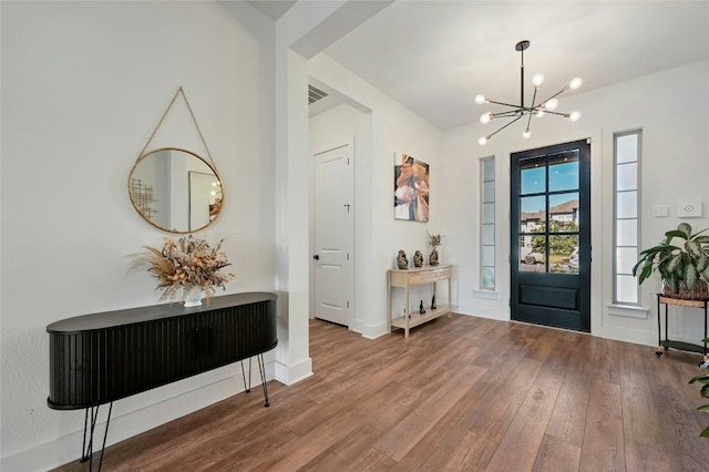 entryway with hardwood / wood-style floors and a notable chandelier