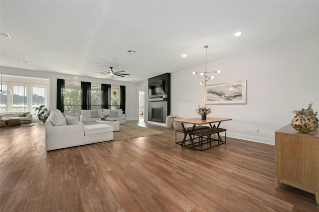 living room with hardwood / wood-style flooring and ceiling fan with notable chandelier