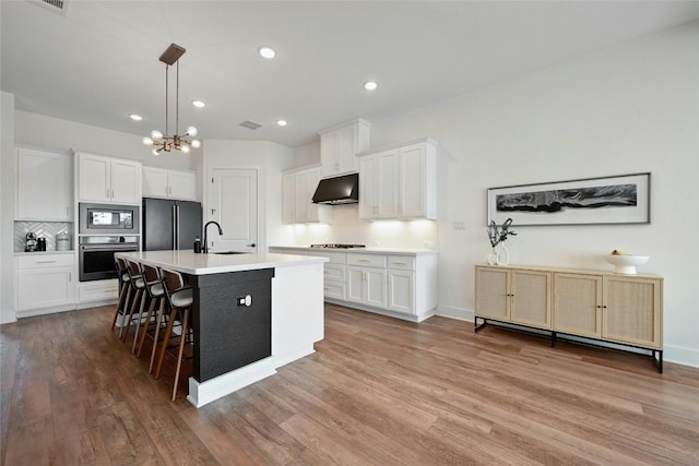 kitchen featuring hardwood / wood-style flooring, sink, white cabinets, and appliances with stainless steel finishes