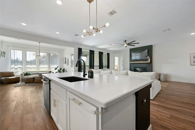 kitchen with hanging light fixtures, an island with sink, a wealth of natural light, and sink