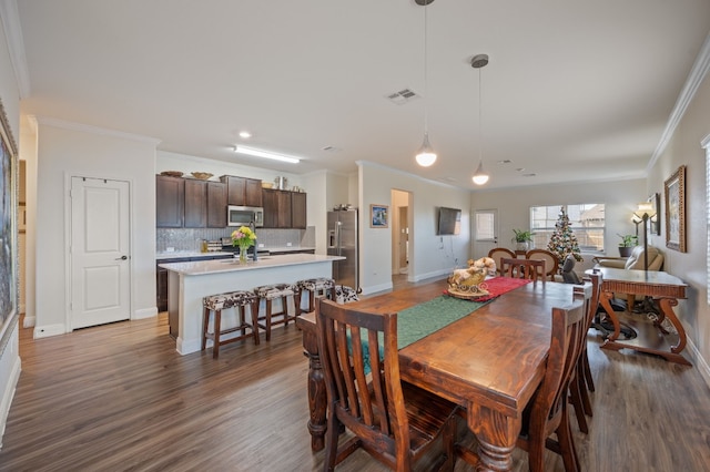 dining room with ornamental molding and dark wood-type flooring