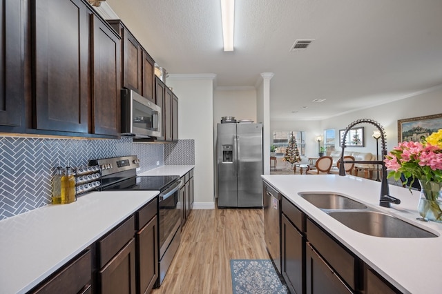 kitchen with decorative backsplash, appliances with stainless steel finishes, crown molding, and sink