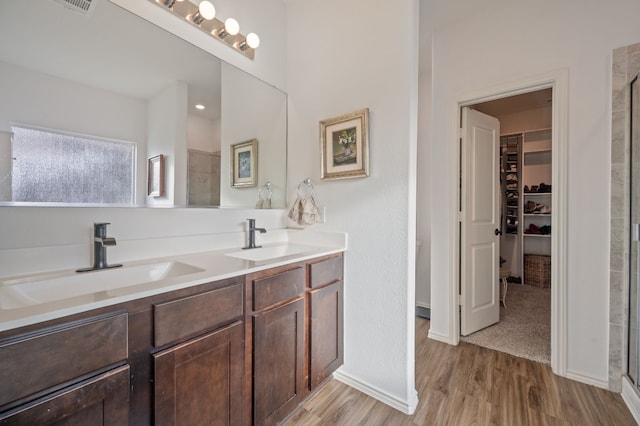 bathroom with hardwood / wood-style flooring, vanity, and a shower with shower door