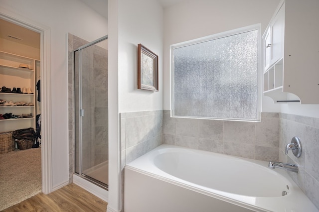 bathroom with independent shower and bath and hardwood / wood-style flooring