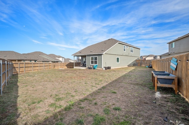 rear view of house featuring a lawn and central AC unit