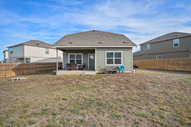 back of property with a lawn and a patio