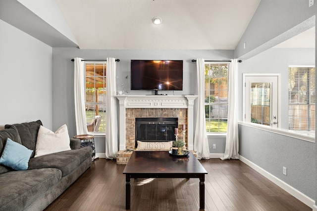 living room featuring a brick fireplace, dark hardwood / wood-style floors, and vaulted ceiling