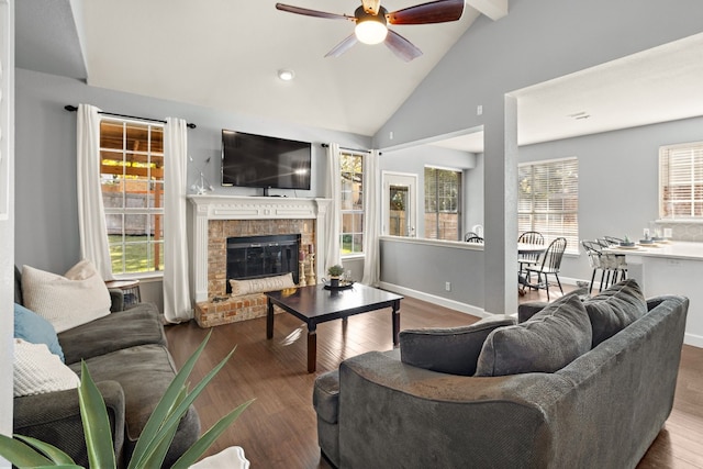 living room with ceiling fan, wood-type flooring, lofted ceiling, and a brick fireplace