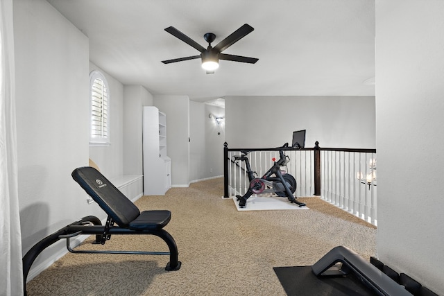 exercise room featuring ceiling fan with notable chandelier and light colored carpet