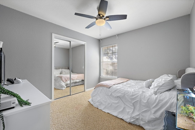 carpeted bedroom featuring ceiling fan and a closet