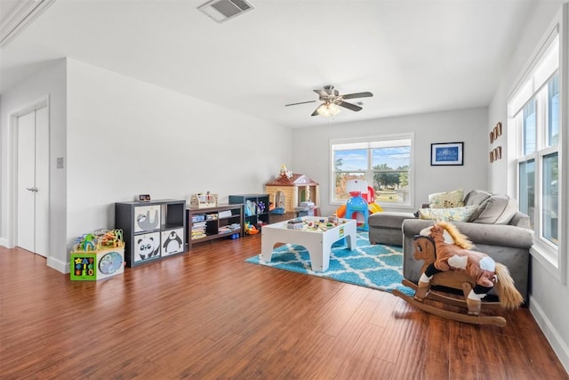 living room with ceiling fan and dark wood-type flooring