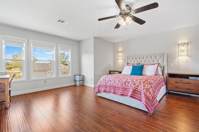 bedroom with multiple windows, dark wood-type flooring, and ceiling fan