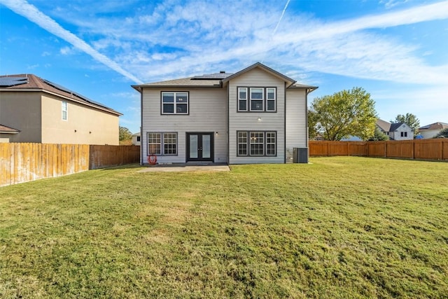 back of property featuring french doors, a yard, and central AC