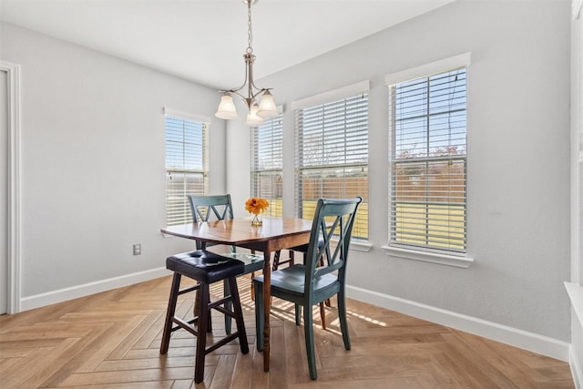 dining room with light parquet flooring, an inviting chandelier, and a wealth of natural light