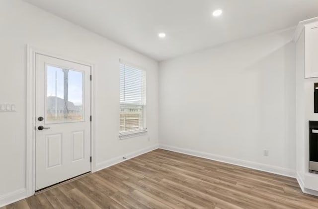 foyer entrance with a wealth of natural light and light wood-type flooring