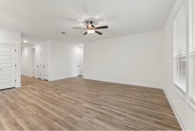 unfurnished living room featuring ceiling fan, light hardwood / wood-style floors, and a wealth of natural light