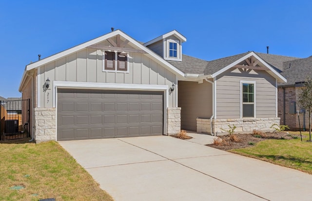 217 Canyoncrest Way, Liberty Hill, TX 78642 - view of front facade featuring stone siding, a garage, concrete driveway, board and batten siding, and a shingled roof