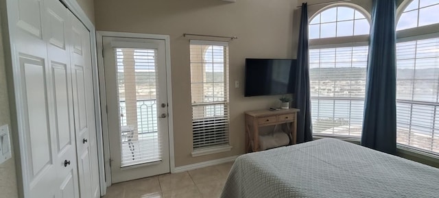 tiled bedroom with access to outside and multiple windows