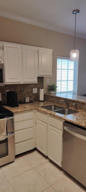 kitchen featuring backsplash, crown molding, sink, white cabinetry, and stainless steel appliances