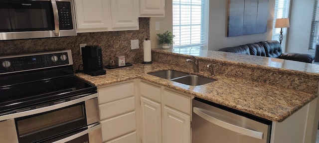 kitchen featuring kitchen peninsula, white cabinetry, sink, and appliances with stainless steel finishes