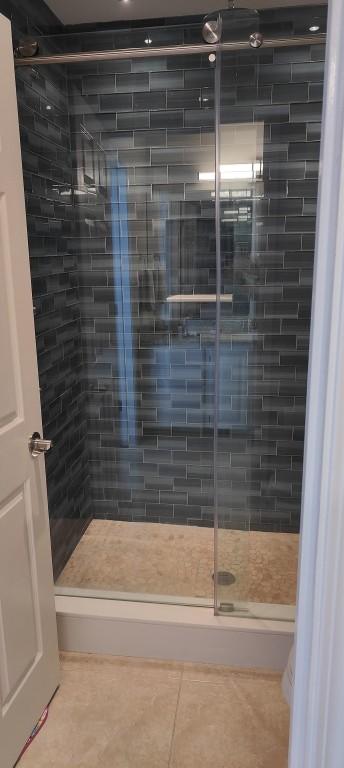 bathroom featuring tile patterned flooring and an enclosed shower