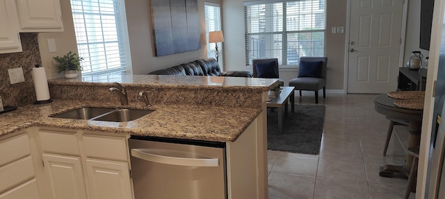 kitchen with sink, light tile patterned floors, kitchen peninsula, decorative backsplash, and white cabinets