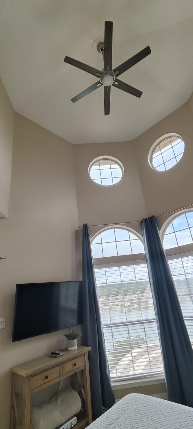 bedroom featuring ceiling fan and a high ceiling