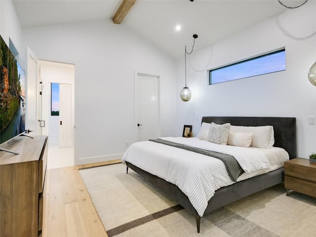 bedroom with lofted ceiling with beams and light hardwood / wood-style flooring