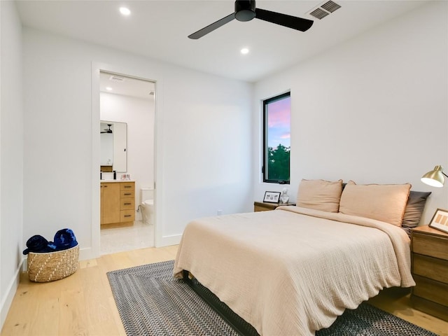 bedroom featuring ceiling fan, light wood-type flooring, and connected bathroom