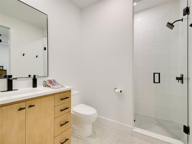 bathroom with vanity, toilet, and tiled shower