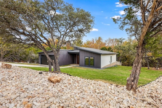 back of house featuring a garage and a lawn