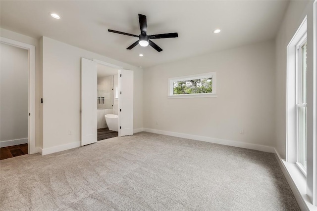 unfurnished bedroom with carpet, ensuite bathroom, and ceiling fan