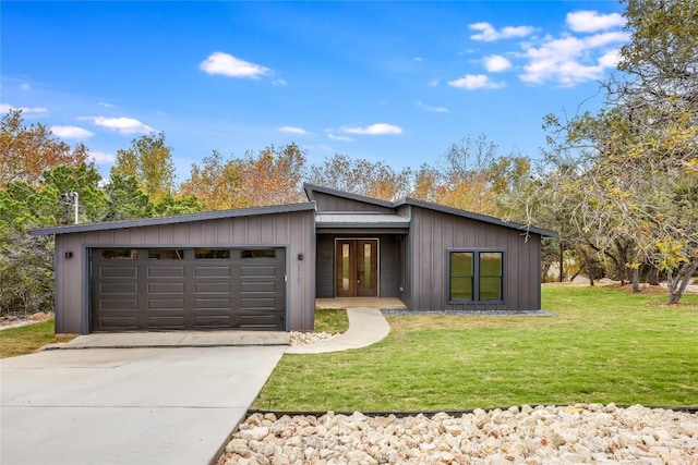 view of front of house with french doors, a front yard, and a garage