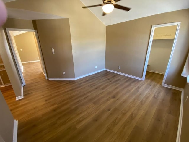1005 N Lbj Dr Unit A-5, San Marcos, TX 78666 - unfurnished bedroom with wood finished floors, a walk in closet, baseboards, lofted ceiling, and ceiling fan