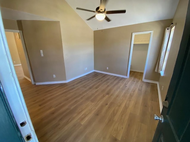 1005 N Lbj Dr Unit A-5, San Marcos, TX 78666 - unfurnished bedroom featuring lofted ceiling, wood finished floors, baseboards, a walk in closet, and a ceiling fan