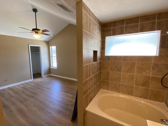 1005 N Lbj Dr Unit A-5, San Marcos, TX 78666 - full bathroom with baseboards, a ceiling fan, wood finished floors, lofted ceiling, and shower / tub combination