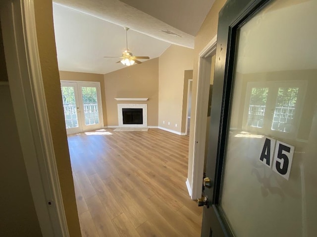 1005 N Lbj Dr Unit A-5, San Marcos, TX 78666 - unfurnished living room with a ceiling fan, vaulted ceiling, light wood-type flooring, french doors, and baseboards