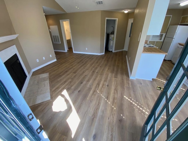 1005 N Lbj Dr Unit A-5, San Marcos, TX 78666 - unfurnished living room featuring baseboards, light wood-style flooring, and a fireplace with flush hearth