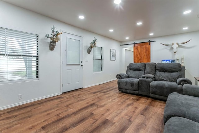 living room with a barn door and dark hardwood / wood-style flooring