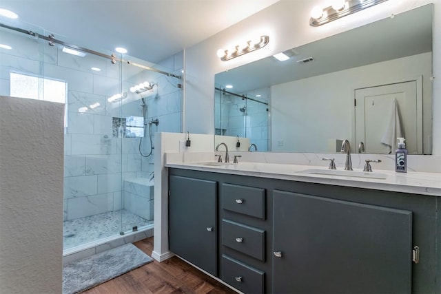 bathroom with hardwood / wood-style flooring, vanity, and a shower with shower door